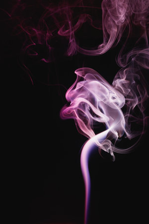 Purple smoke on a black background. Colored smoke. Incense stick smoke illuminated by purple light.の写真素材