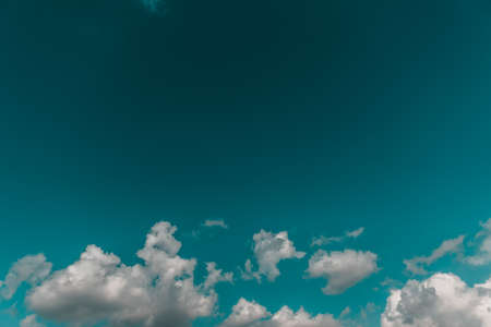White cotton wool clouds on a sunny day. A continuous stream of clouds across the summer sky.の写真素材