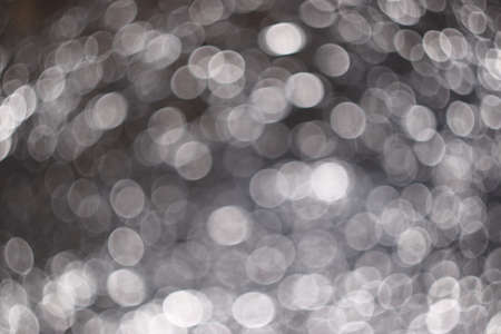 Abstract background obtained from crumpled foil with moving lighting and a defocused camera. Sparkling snow, water or dew in the sun. Bokehの写真素材