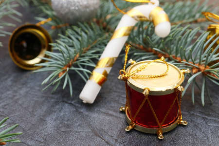 Merry christmas and a happy new year! A sprig of the green symbol of the winter holidays - spruce with decorations on a background of gray artificial leather backing.の写真素材