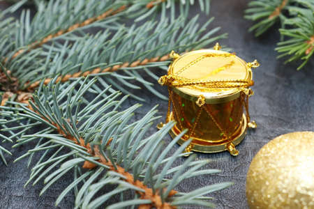 Merry christmas and a happy new year! A sprig of the green symbol of the winter holidays - spruce with decorations on a background of gray artificial leather backing.の写真素材