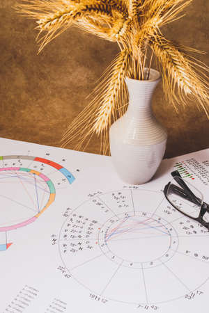The workplace of an astrologer, magician and sorcerer of our time. Hobby during the coronavirus pandemic. Astrological charts and tables built with the help of modern gadgets, laid out on the table.の写真素材