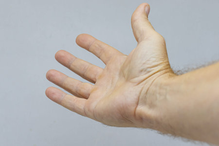The outstretched hand of a man on a light background.の写真素材