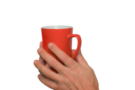 A cup of tea in the hands of a man in close-up. Red on the outside and white inside the cup. Isolate on a white background.の写真素材