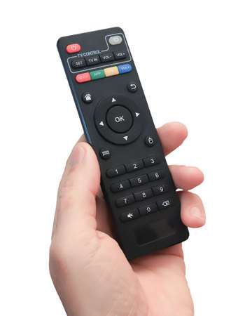 A man's hand with a close-up remote control. Black remote control with colored buttons. Isolate on a white background.の写真素材