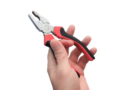Master's hand with close-up pliers. Trade winds with insulated plastic handles. Isolate on a white background.の写真素材