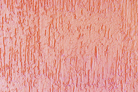 The pink plaster texture of the exterior wall of the building is close-up.の写真素材