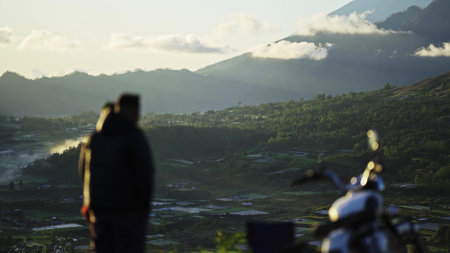 silhouettes of men against the background of mountains A man stands and takes a selfie the atmosphere is pleasant.の写真素材