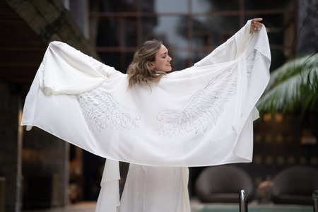 a woman with angel wings, a portrait of a beautiful woman with angel wings. An angel with long curly hair.の写真素材