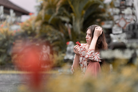 a model girl in a stylish suit, meditating near a shrine, posing for a temple in a tropical forest, sitting in a thoughtful 4k poseの写真素材