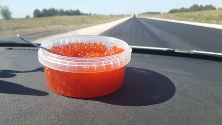 a jar of red caviar is in the car that goes on the roadの写真素材