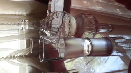 a glass of water and a clear decanter stand on the table and are reflected in the mirror topの写真素材