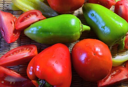 green and red bell peppers and fresh tomatoes are on the tableの写真素材