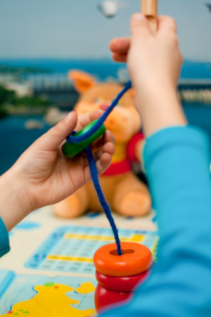 child collects logical toy on a laceの写真素材