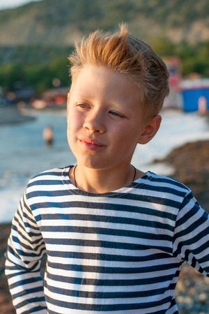 boy standing on the beach in summer day striped vestの写真素材