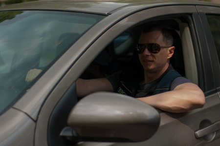 man driving a car in a coffee-colored sunglasses