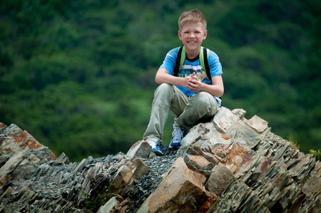 boy standing on a rock in the forest background summer dayの写真素材
