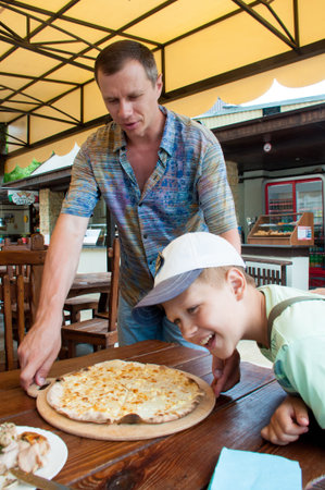 father and son in a cafe with pizza warm summer dayの写真素材
