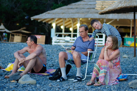 family sitting on the beach summer warm eveningの写真素材