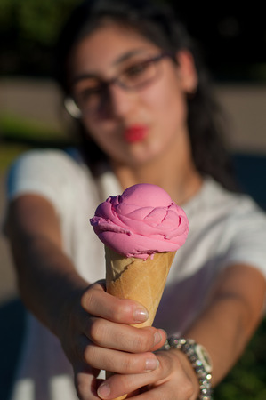 Girl with pink ice-cream fun outdoorsの写真素材