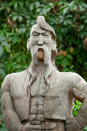 Cossack made of wood with a forelock and mustache on a background of green leavesの写真素材