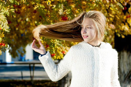 girl with flowing hair on the background of a tree with rowanの写真素材