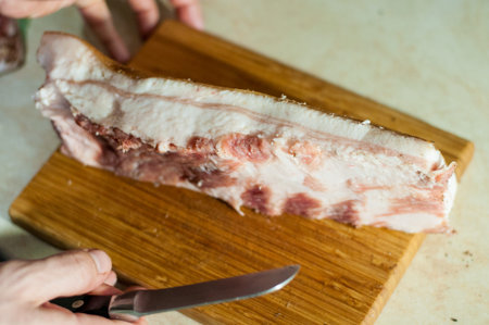 man cuts the raw lard for saltingの写真素材