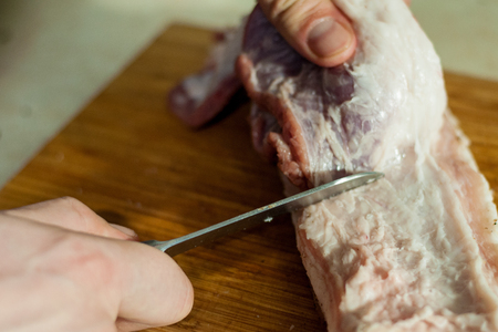 man cuts the raw lard for saltingの写真素材