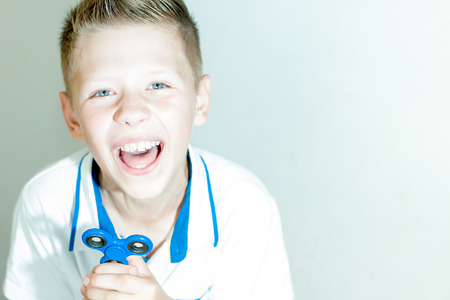 Boy on an outstretched hand holds a blue spinnerの写真素材