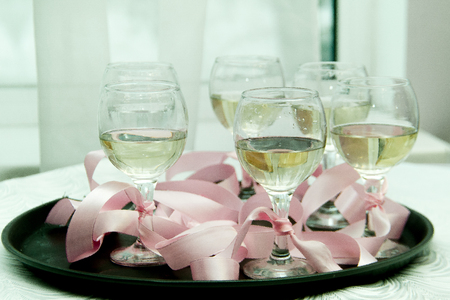 glasses with champagne on a tray tied with a pink ribbonの写真素材