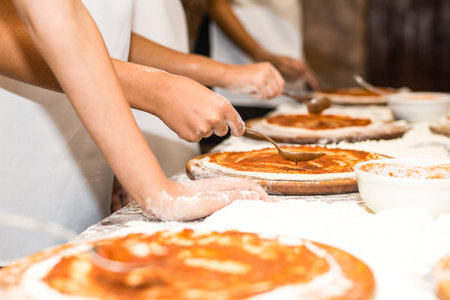 Close up of female hands kneading dough on table in bakeryの写真素材