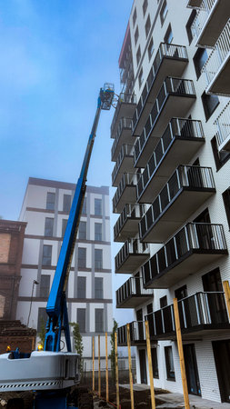 Construction of a new apartment building with a crane against the blue sky