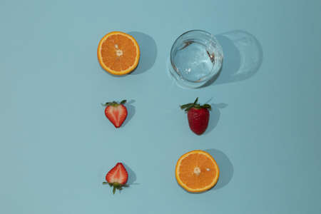 Summer scene with bright blue beach towel and glass and orange fruit and shell. Cold drink or refresment concept.の写真素材