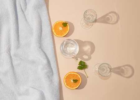 Summer scene with bright blue beach towel and glass and orange fruit. Cold drink or refreshment concept.の写真素材