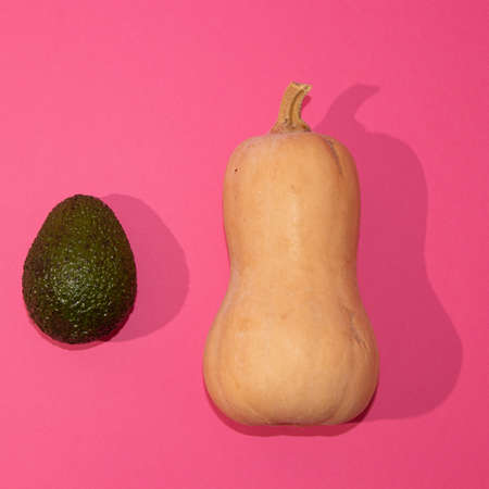 Minimal natural flat lay. Kiwi and pumpkin on pink background.の写真素材
