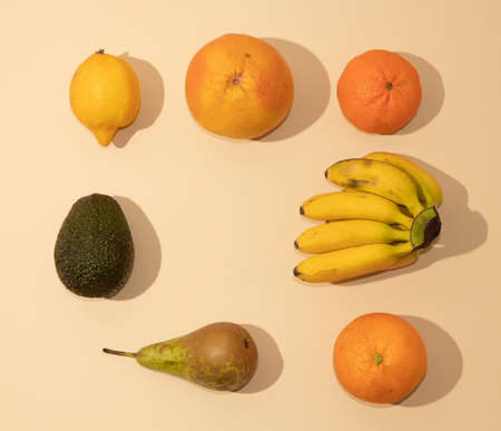 Neatly arranged fresh fruit on sandy colored background. Minimal flat lay.の写真素材