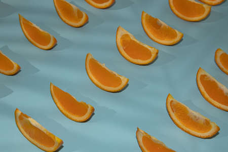 Colorful fruit pattern of fresh orange slices on light blue background top view orange fruit pattern background Flat lay orange background cut and full orangeの写真素材