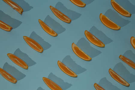 Orange slices, pattern, on a light blue background, with shadows. Flat lay inspiration.の写真素材