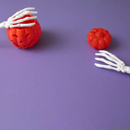 Ghost for Halloween and shadow of the witch with pumpkin on a purple background. Minimal flat lay scene.の写真素材