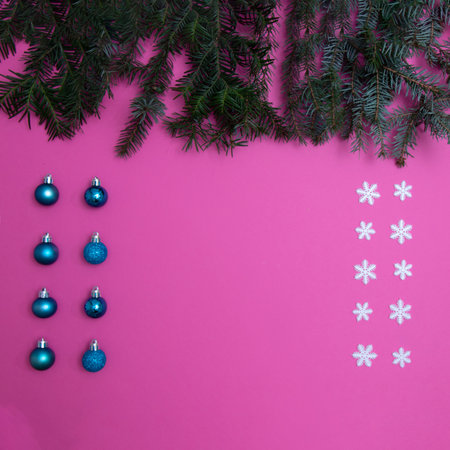 Evergreen trees with snowflakes and Christmas tree decorations on a pink background with copy space. Flat lay minimal scene.の写真素材