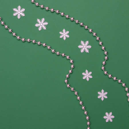Imitation of the road with silver balls and in the middle of the road there are snowflakes on a green background. Flat lay concept.の写真素材