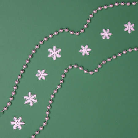 Imitation of the road with silver balls and in the middle of the road there are snowflakes on a green background. Minimal flat lay concept.の写真素材