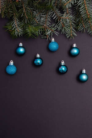Evergreen trees with blue Christmas tree decorations on a black background with copy space. Minimalistic flat lay.の写真素材