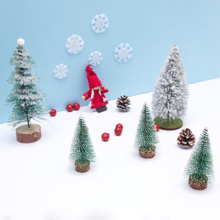 Evergreen trees with Christmas tree decorations on a blue background with copy space and red balls. Minimalistic flat lay.の写真素材