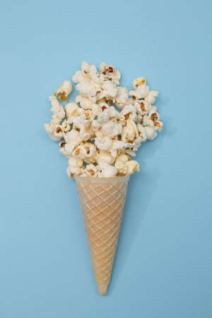 Popcorn ice cream in a cone on a light blue background. minimal flat lay scene.の写真素材