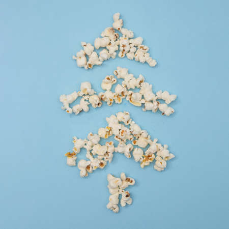 Christmas tree made of popcorn on a blue background. Minimalistic scene.の写真素材