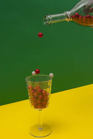 Pouring New Year's decorations from a champagne bottle into a glass. New Year's setting on yellow green background.の写真素材