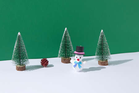 Snowman in a pine forest on snow with one pine cone. Christmas scene.の写真素材