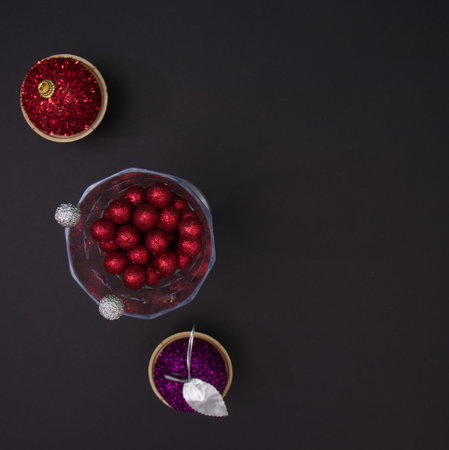 New Year's balls in cones and decoration in a glass on a black background with copy space....