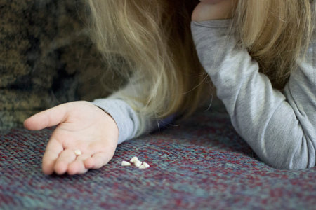Child plays with small objects on a blanket.の写真素材